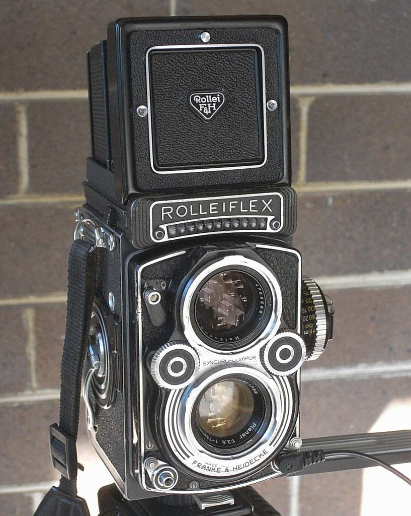 Rolleiflex 3.5F twin-lens reflex camera in black, seen from the front with the viewing hood closed, Planar 75mm f/3.5 taking lens below the viewing lens