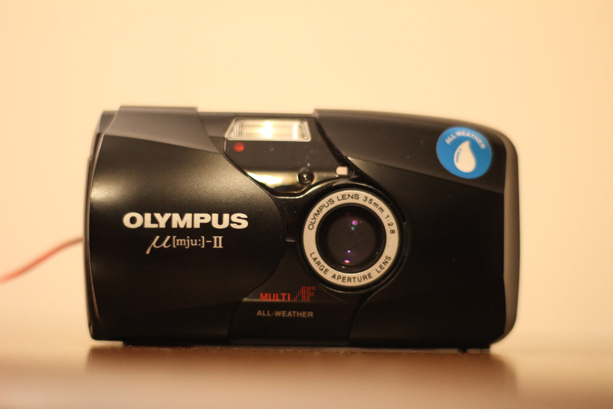 Olympus mju II in black, front view with the lens cover open