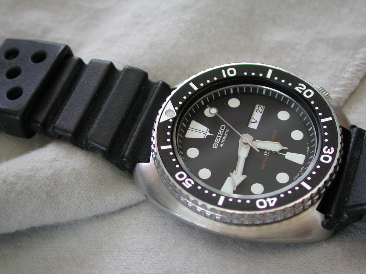 Seiko 6309-7040 dive watch with black dial and bezel on a black rubber strap