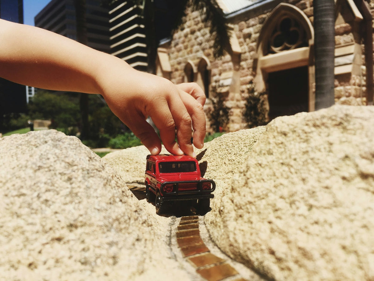A diecast toy car in hand